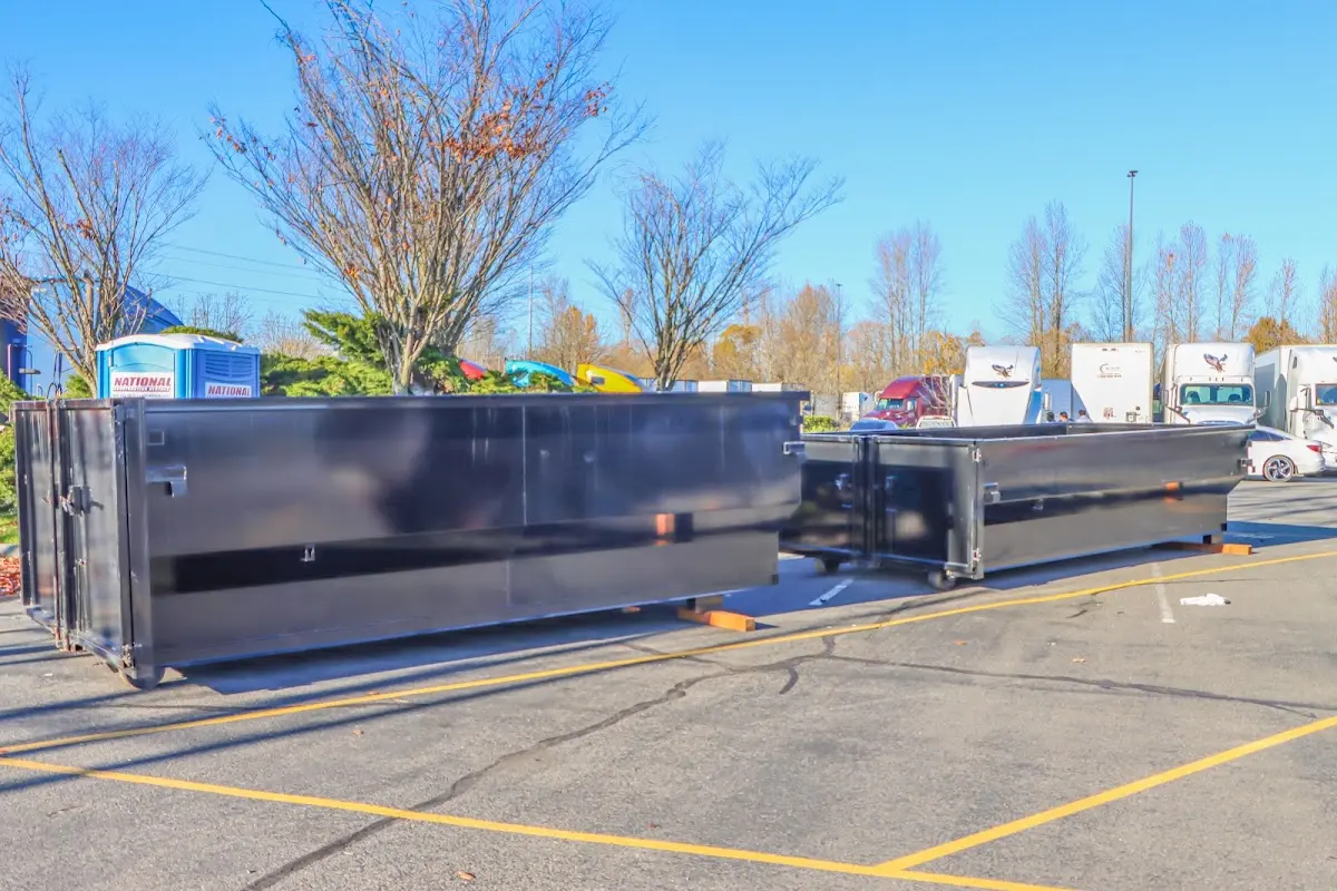 Professional dumpster rental service with roll-off container on residential driveway in Jasper